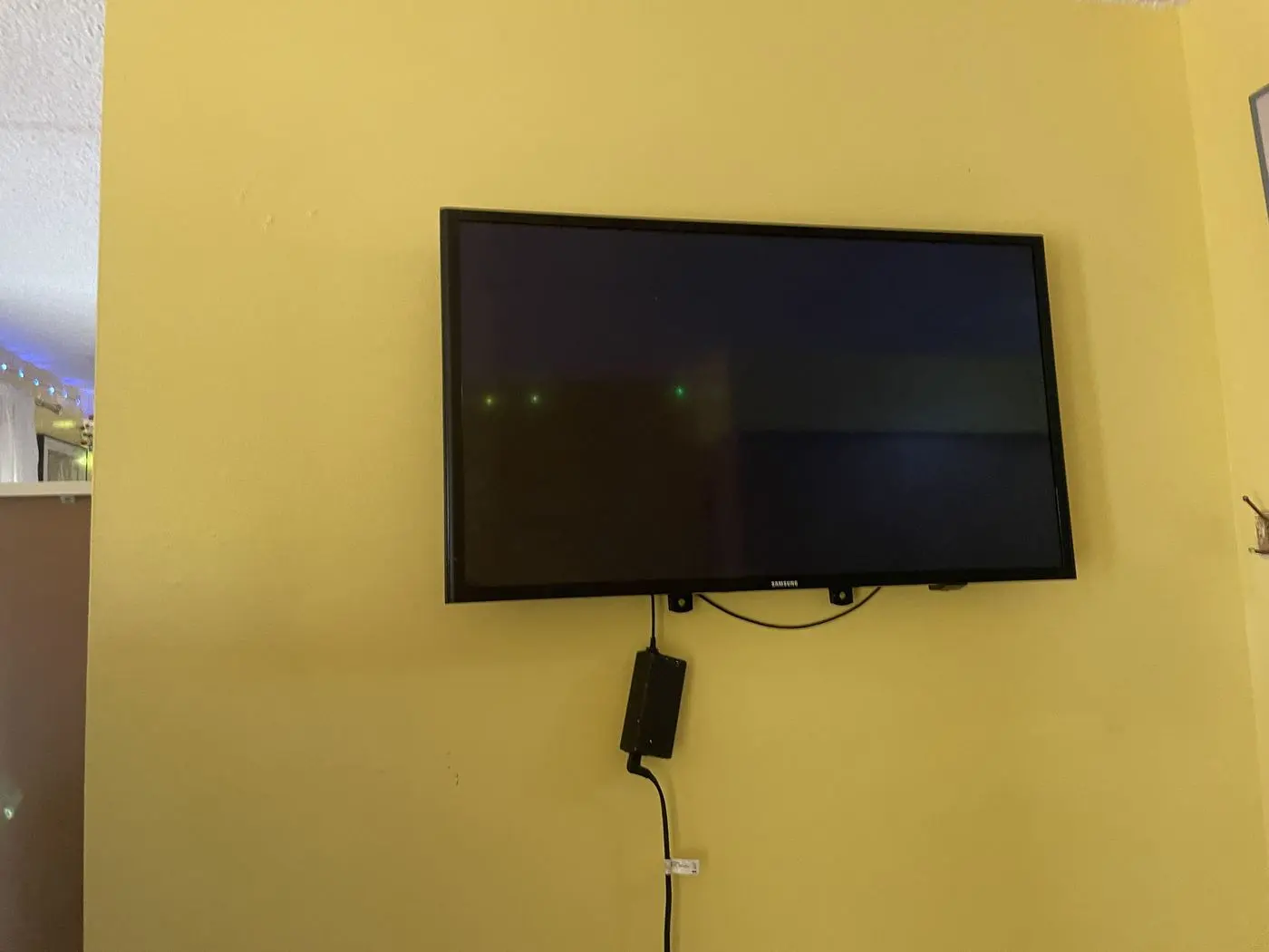 Télé installée au mur sur un support